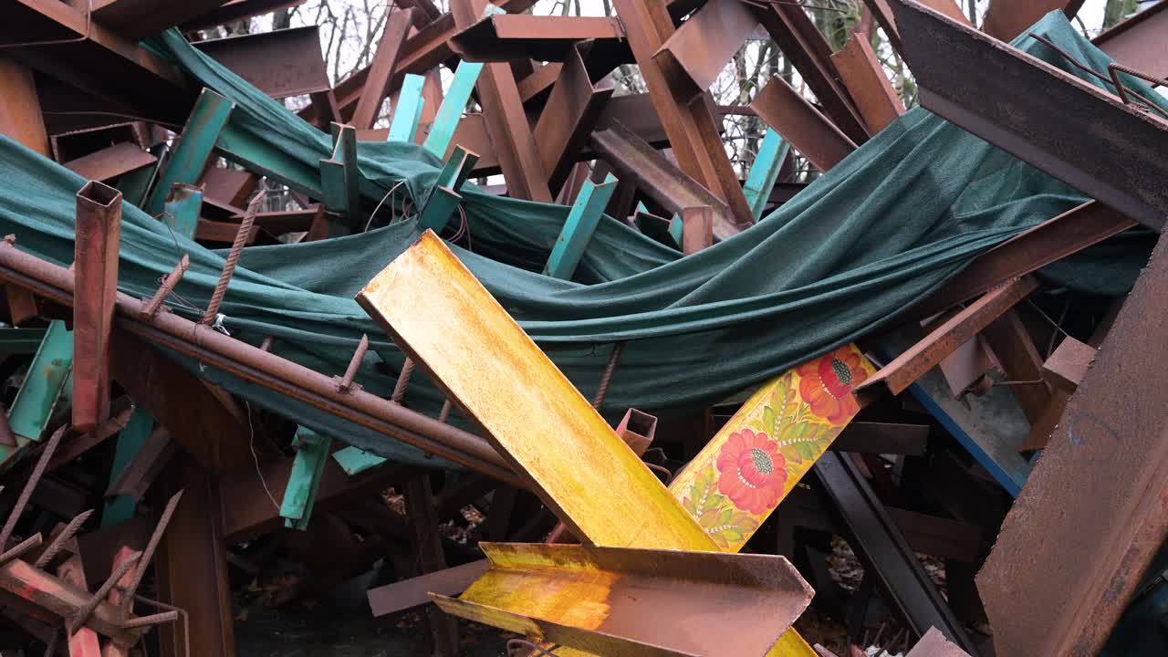 Amid the Ukraine-Russia war, a yellow anti-tank barricade with flower drawings stands among others on a Kyiv street.