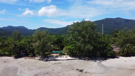 AERIAL:-Revealing-shot-of-the-Jungle-Coast-Surrounded-by-Mountains-on-Koh-Chang-in-Thailand,-Asia