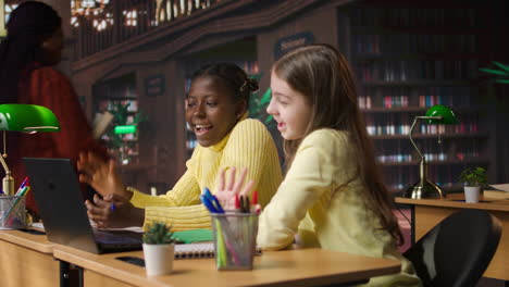 dos chicas estudiando en una biblioteca virtual