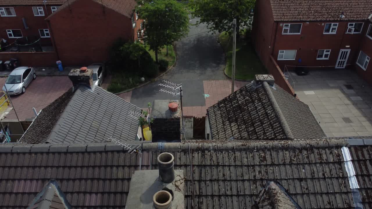 Aerial view looking down over house rooftop chimney tilt up reveal of industrial suburban town