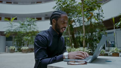 businessman working on laptop in outdoor courtyard