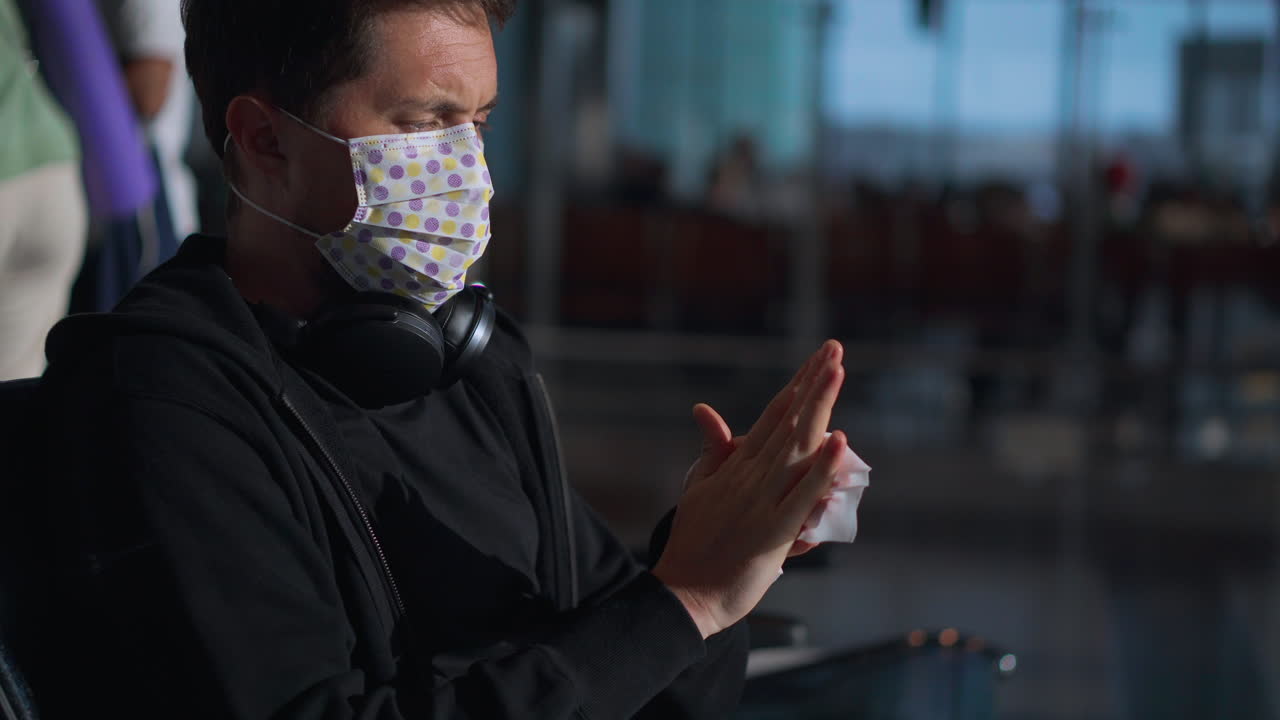 Man sanitizing hands at the airport during pandemic