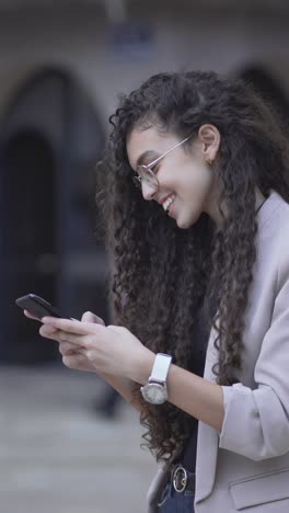 mujer joven enviando mensajes de texto en el teléfono inteligente en la ciudad