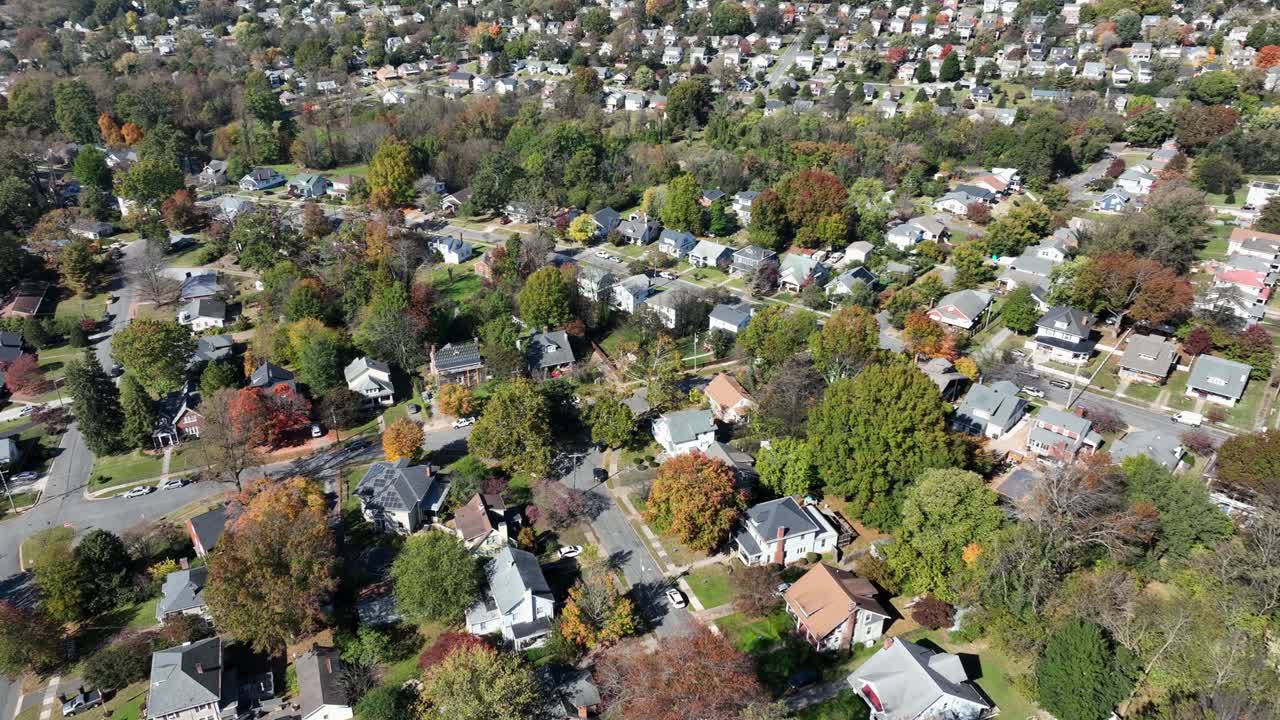 Quaint American neighborhood During Sunny Day in Autumn season Driving cars in street with colored trees in fall. Historic, cathedral and main street on sunny day. Drone top down.