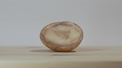 empujar lentamente la patata en mal estado en la tabla de corte