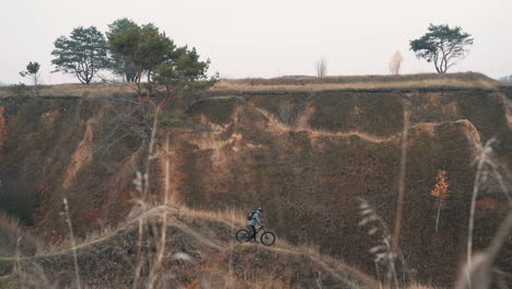 atleta che trasporta una mountain bike in collina 1