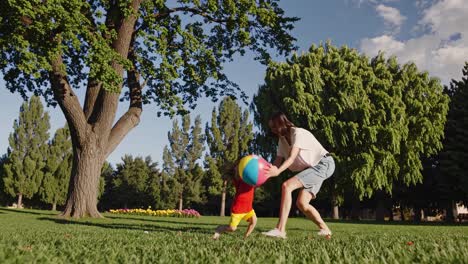 mother and child playing ball in a park