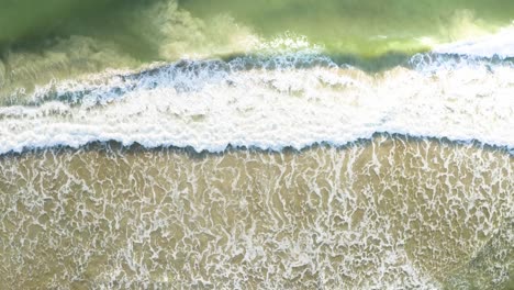 Wunderschöne-Drohnen-Filmaufnahme-Von-Oben,-Die-Sich-Den-Wellen-Eines-Brasilianischen-Strandes-Mit-Smaragdgrünem,-Klarem-Wasser-Bei-Sonnenaufgang-Nähert