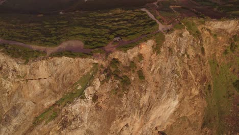 Motorhome-parked-on-high-cliff-at-Cabo-da-Roca-with-sunset,-aerial