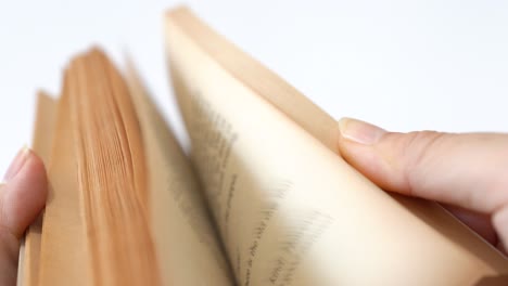 un viejo libro de cuentos volteando por manos femeninas, fondo blanco