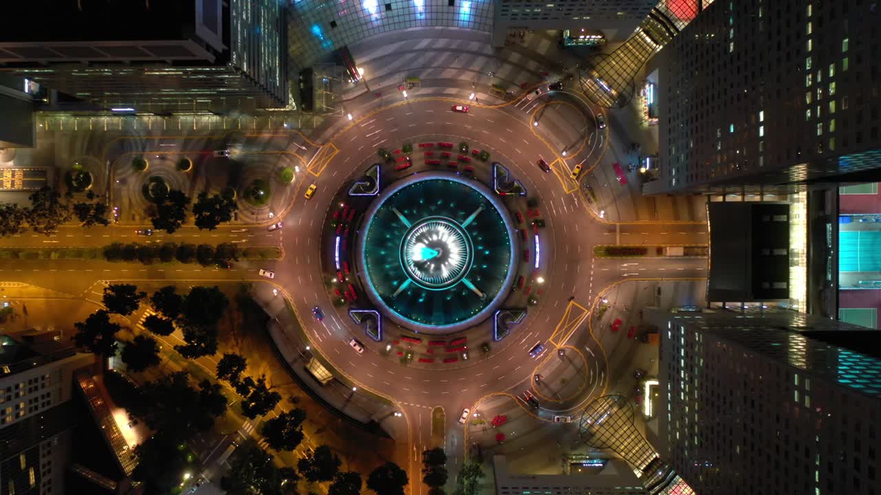 volo di illuminazione notturna sopra la città di singapore famosa cerchio di traffico del centro panoramico aereo topdown 4k