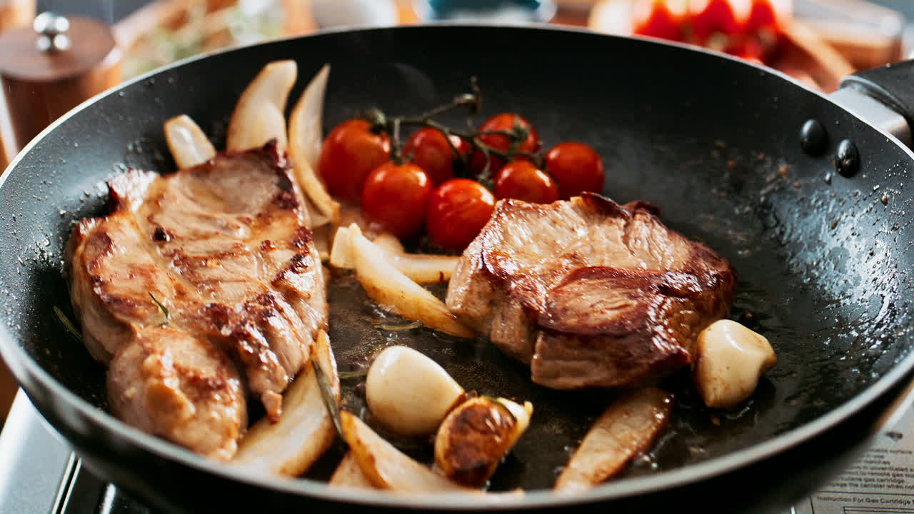 Steak with Tomatoes and Onions Cooking in Pan