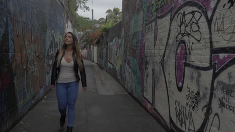 hermosa chica caminando en el callejón con graffiti - street art graffiti - sydney, nsw, australia