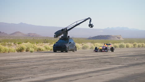 la cámara de cine arm car sigue y filma el coche de fórmula 1 conduciendo por la pista de un aeropuerto en las vegas, nevada.