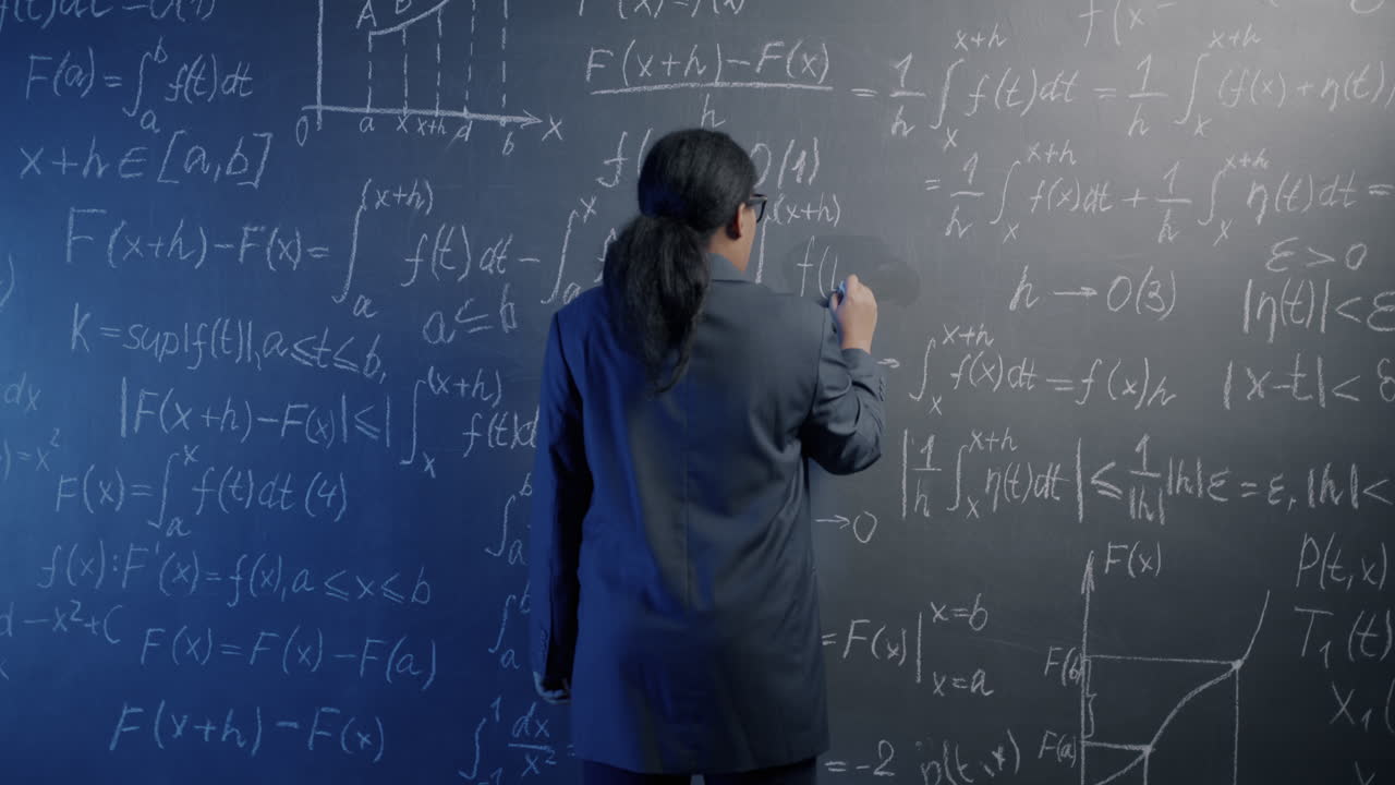 Teacher Writing Mathematical Equations on a Blackboard