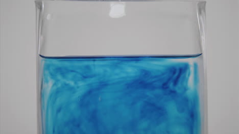 tinte azul se difunde a través de un vaso de agua 1