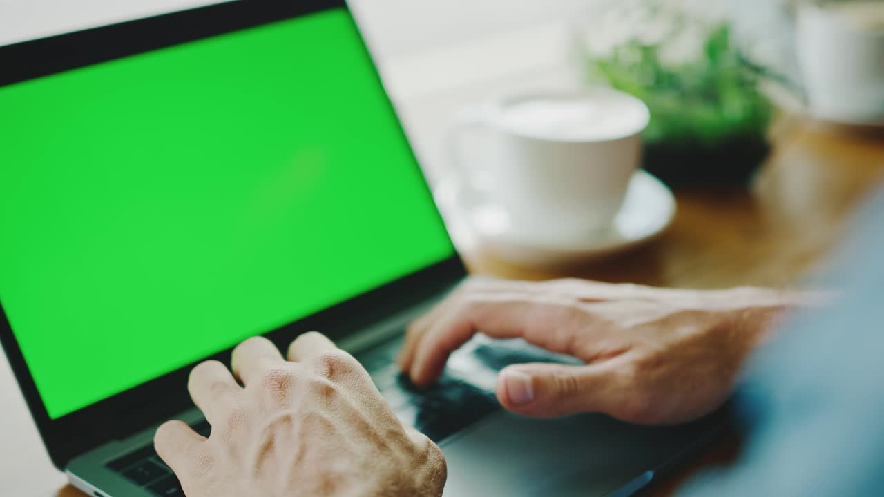 hombre trabajando en la pantalla verde de la computadora portátil