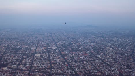 avión comercial sobrevuela la ciudad de méxico a la hora azul, después del atardecer