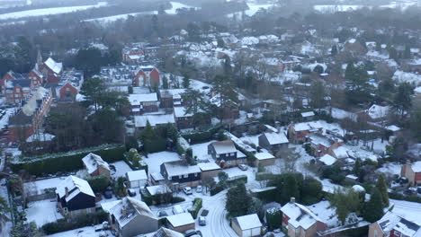 Drone-aerial-footage-of-Houses-in-England-on-a-Snowy-Morning-With-Rooftops-Covered-in-Snow-and-snow-on-the-roads,-in-English-town