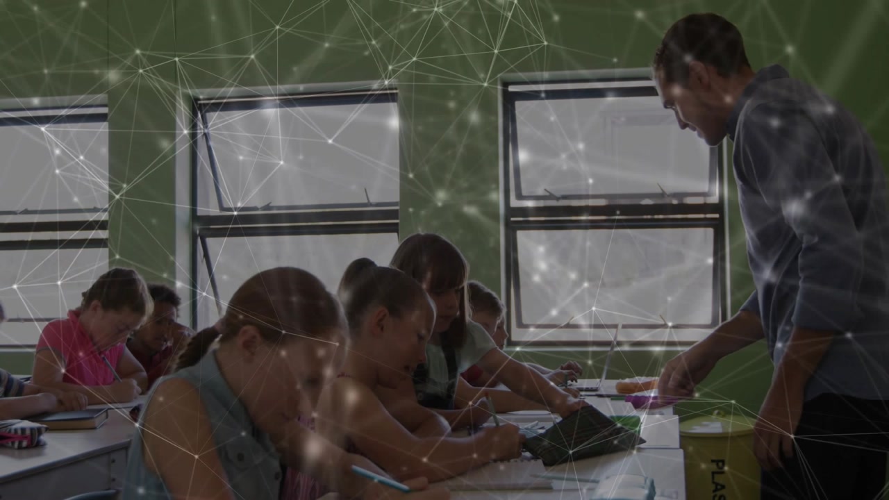 Teacher walking along row, leaning and pointing at papers, assisting students with network overlay