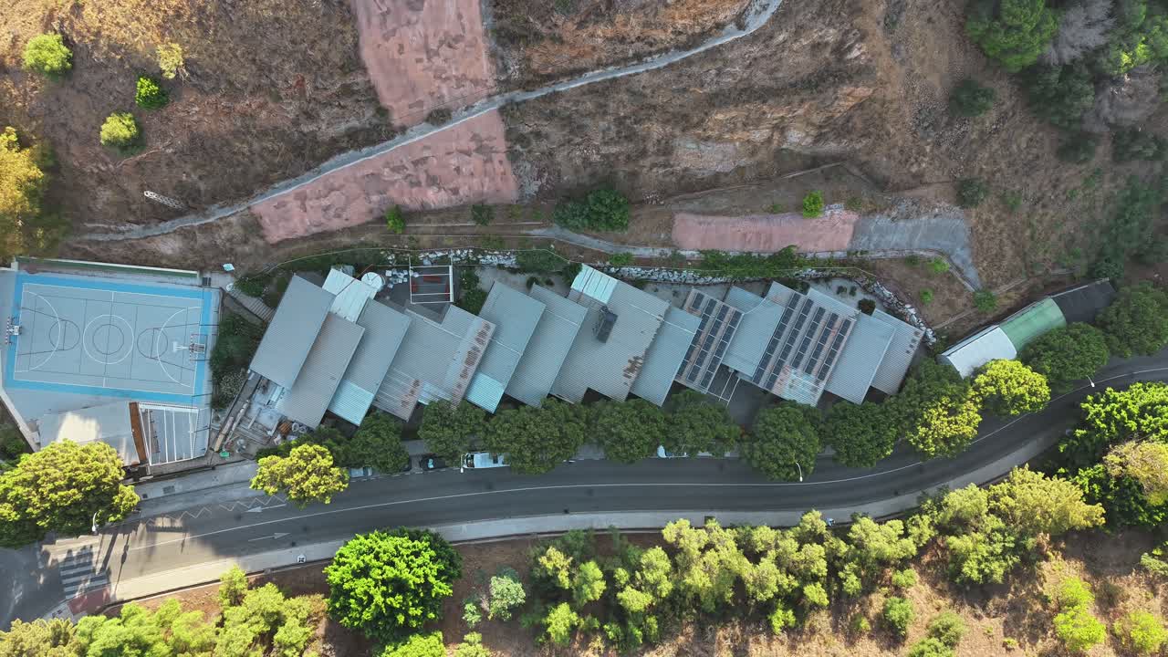 Aerial view of hillside buildings and lush surrounding trees