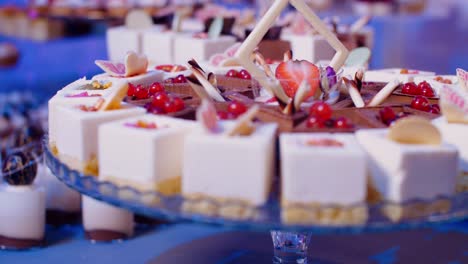 small cakes and mousse desserts on display stand in candy bar, push in