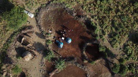 4k aerial view from above of a camp of kenyans and tourists in a savanna area of the lake natron region, kenya, east africa