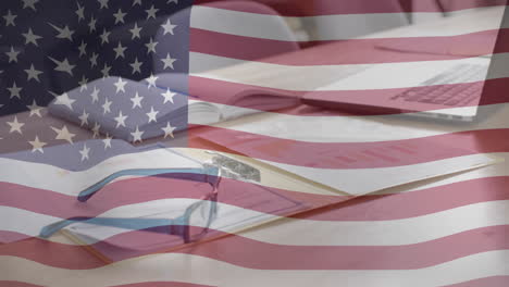 animación de la bandera estadounidense sobre el escritorio de la oficina con documentos, gafas y portátil
