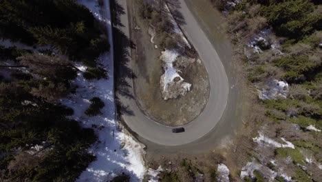 furgoneta dando la vuelta a la esquina en zigzag en las montañas toma aérea desde arriba