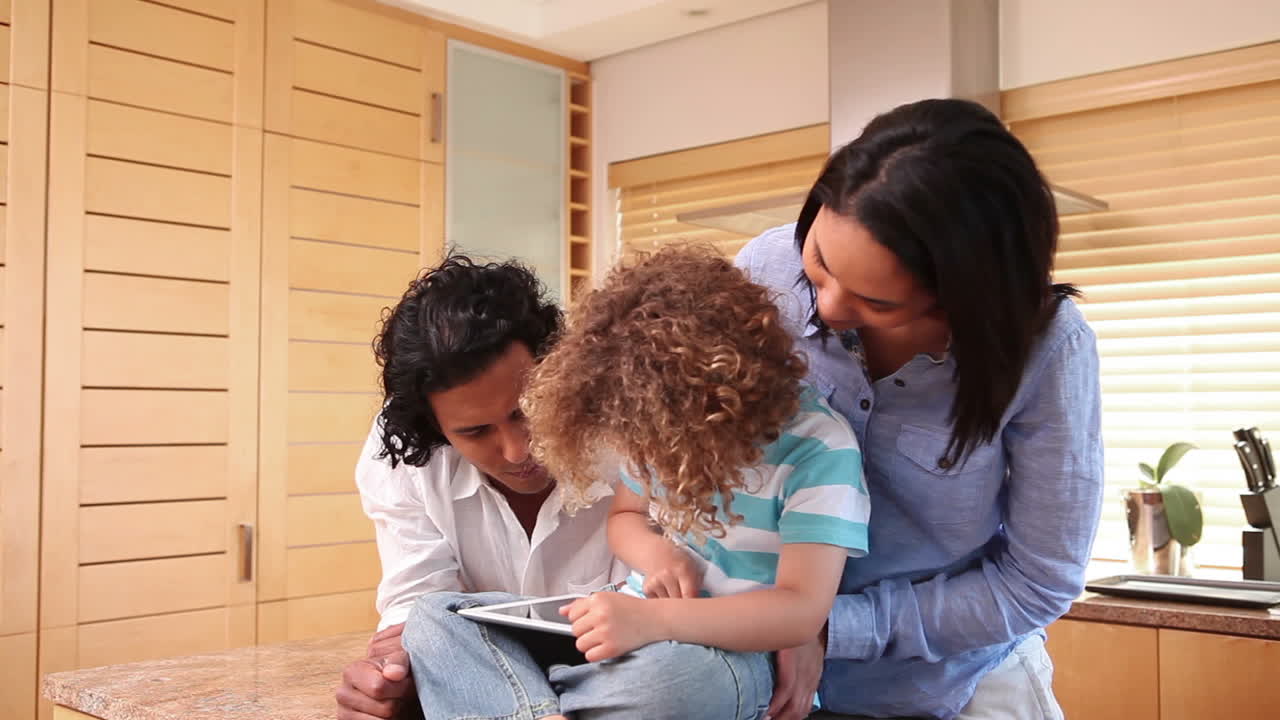 Famiglia con tablet in cucina.