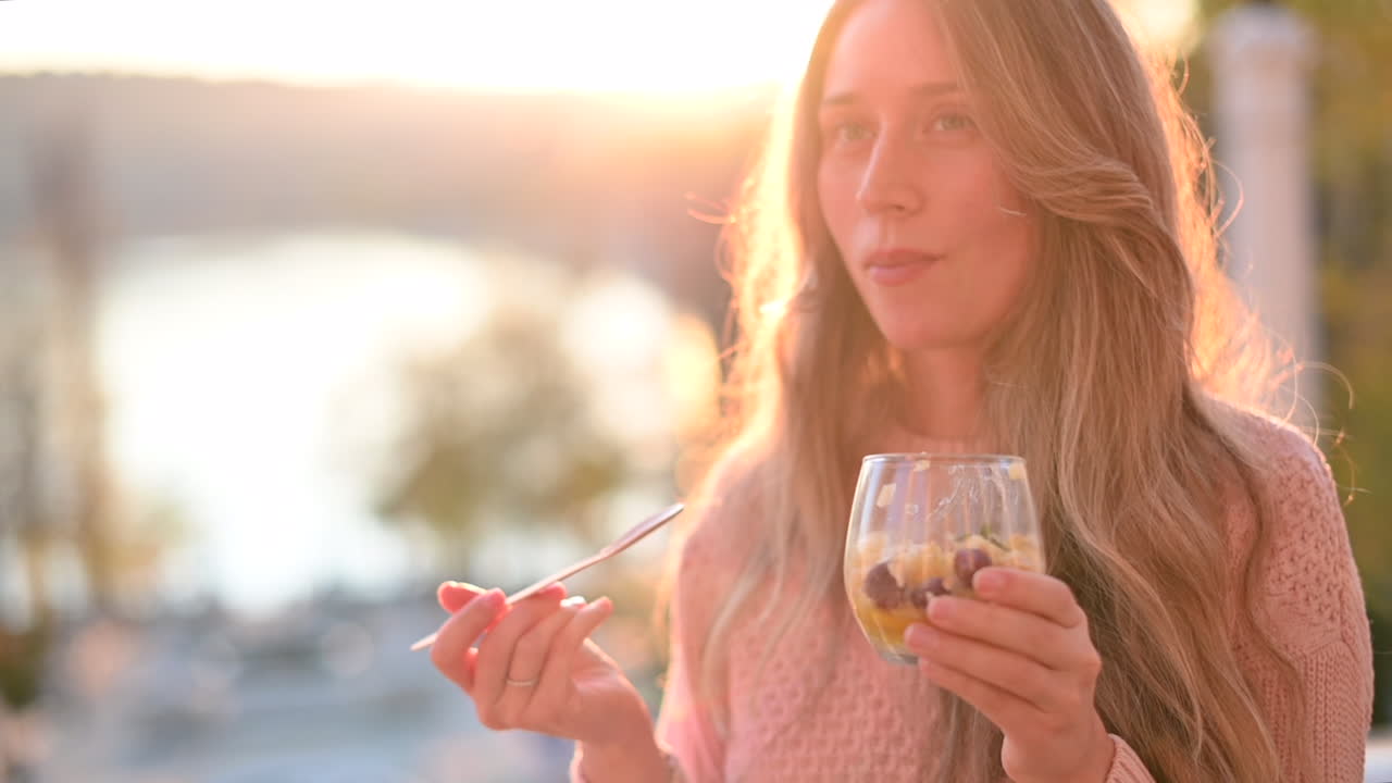 Donna che mangia una macedonia con semi di chia in un parco al tramonto