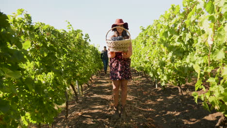hermosa mujer caucásica levantando una canasta con uvas