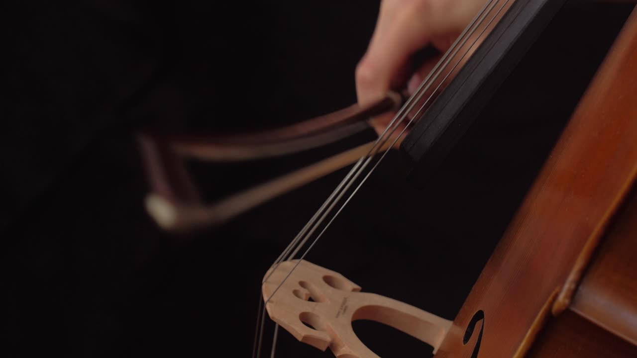 close up of woman playing staccato on the cello