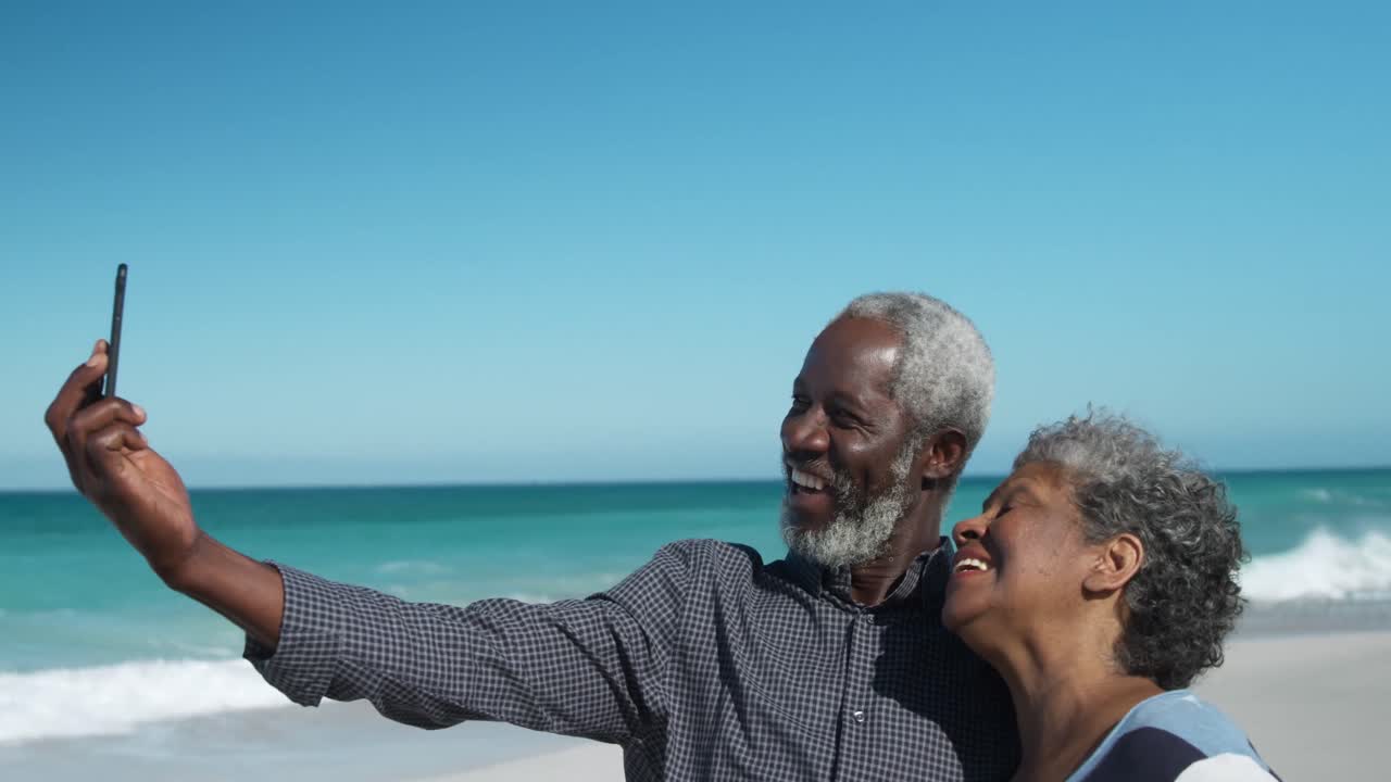 Senior couple taking photos at the beach