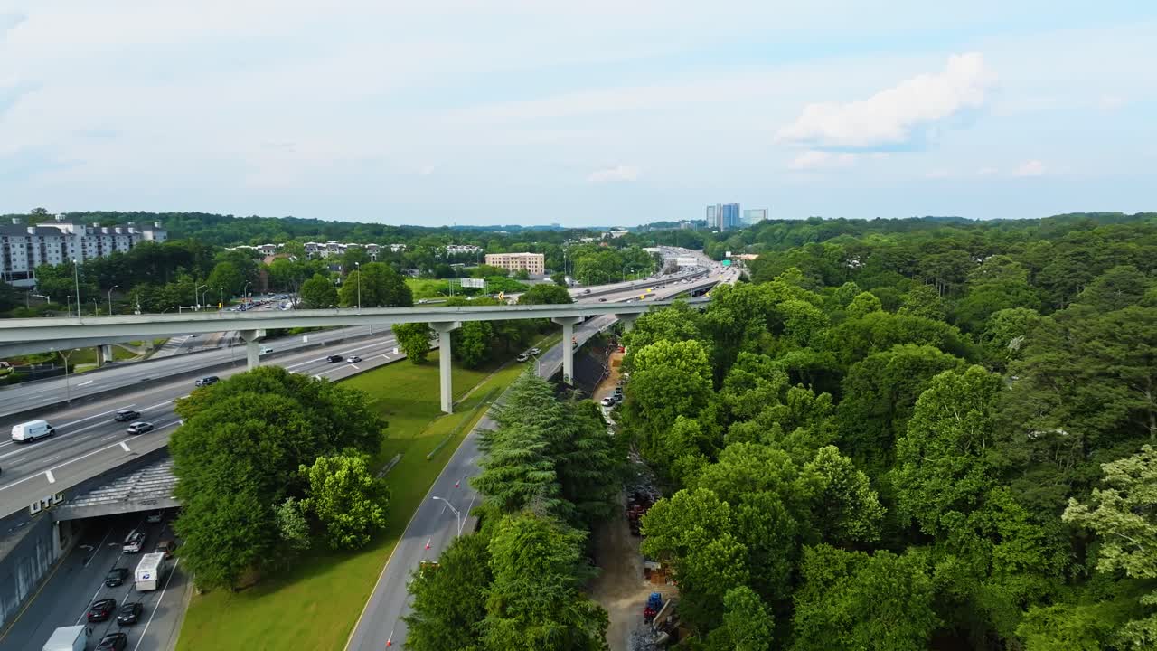 Aerial flyover busy highways in suburb district of Atlanta, Georgia. Sunny day in green lush suburb area. Small Neighborhood with houses and homes. Wide shot