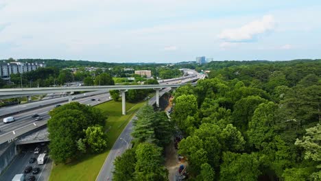 aerial flyover busy highways in suburb district of atlanta, georgia. sunny day in green lush suburb area. small neighborhood with houses and homes. wide shot