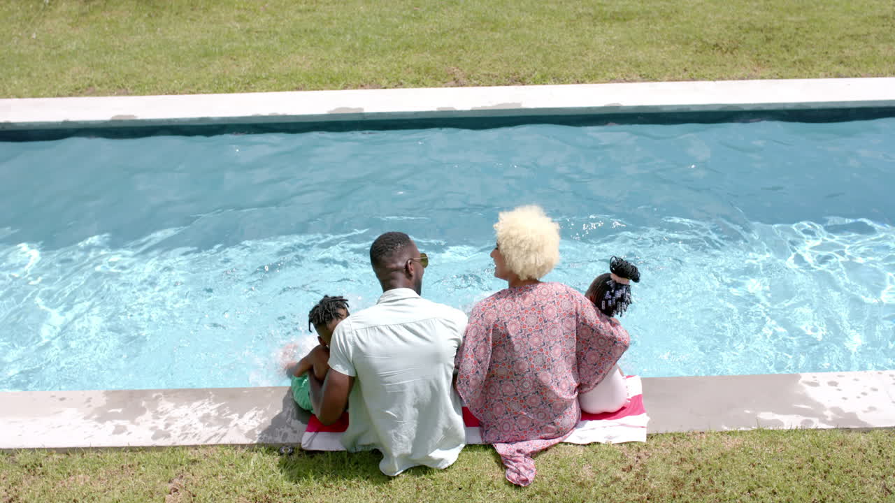 familia afroamericana disfrutando del tiempo en la piscina en casa