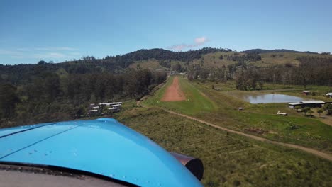 cabina pov pequeño arbusto avión turbohélice aterrizando en pista de tierra