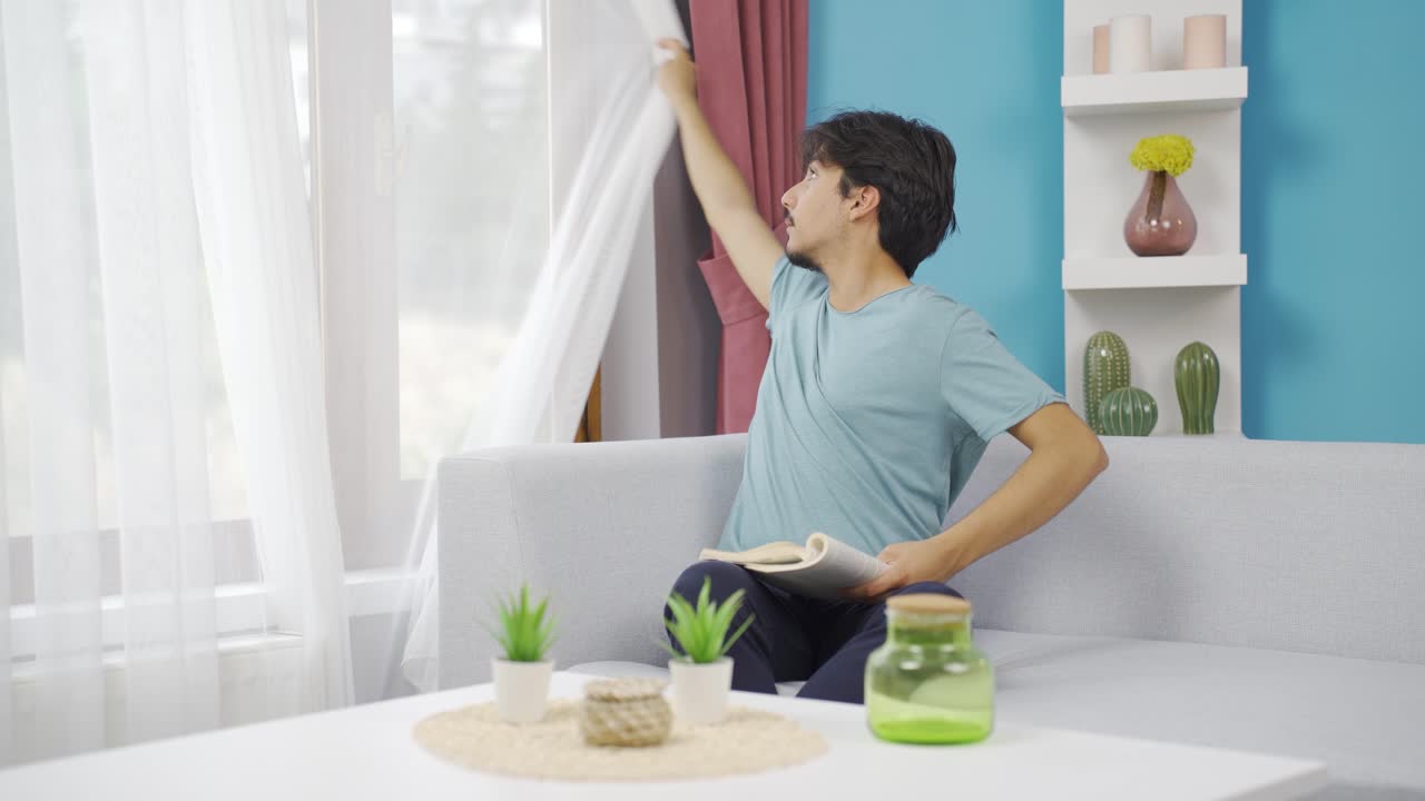 집의 커튼을 닫는 사람.