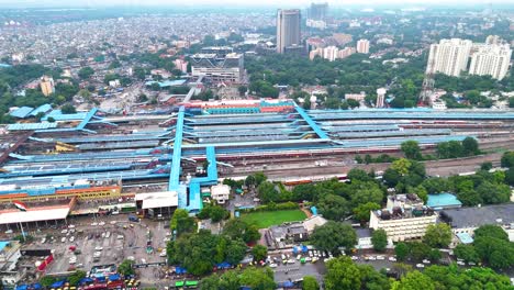 aerial revealing shot of the new delhi train station with people entering the station, india