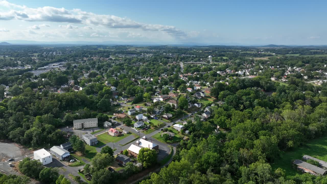 Vista aerea di Waynesboro, Virginia, in un chiaro pomeriggio. Case residenziali, strade alberate, area industriale e le lontane Blue Ridge Mountains. Quartiere suburbano e paesaggio naturale. Campo lungo