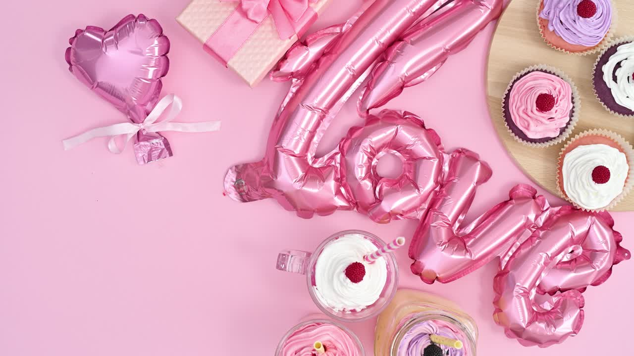 los globos de decoración del día de san valentín y los pasteles se mueven en el lado derecho del tema rosa pastel.