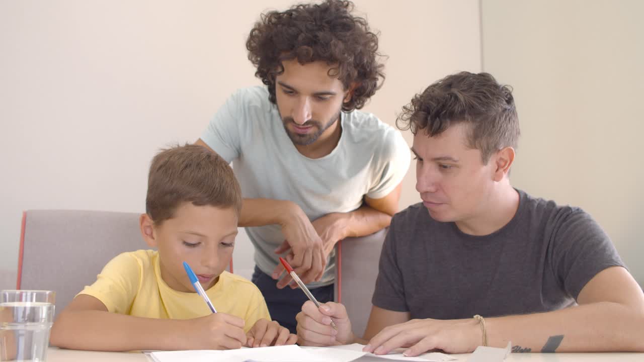 dos padres ayudando a su hijo con la tarea de escribir