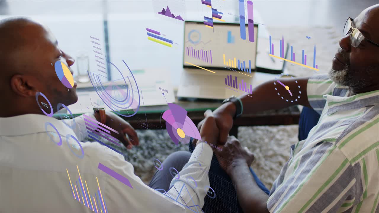 Senior mentor pointing at laptop and guiding mentee, analyzing business charts with floating graphs