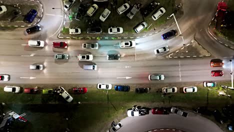 el avión no tripulado asciende por encima de los coches estacionados en la mediana de la hierba y gira en la rampa por la noche