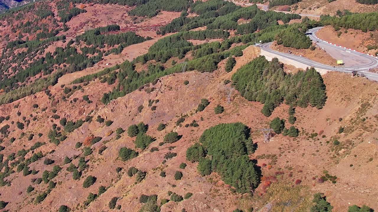 Udsigt over klippefyldt terræn med træer nær motorvej i Granada, Spanien
