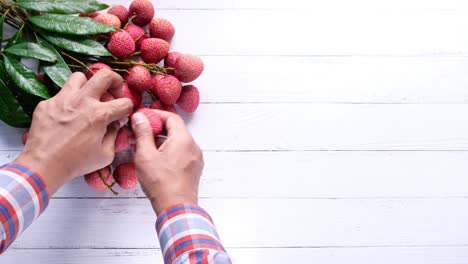 person picking fresh lychees