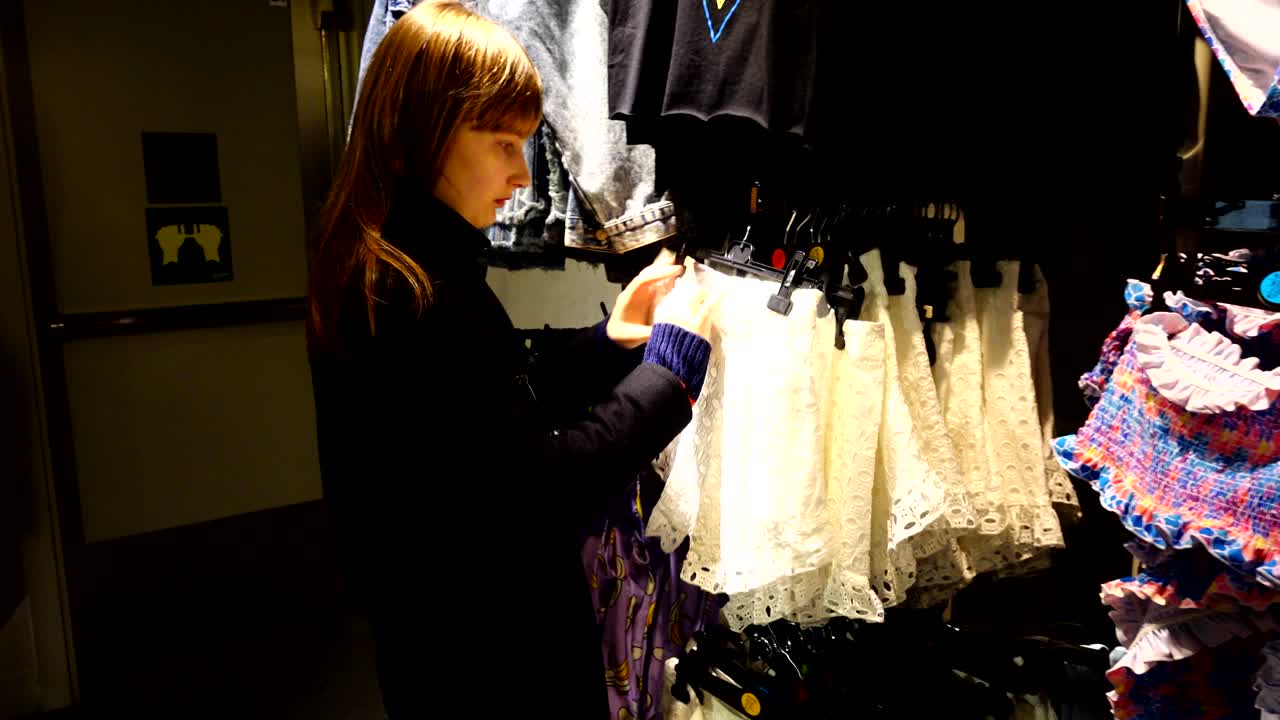 유럽의 쇼핑몰에서 소녀는 옷을 선택합니다.