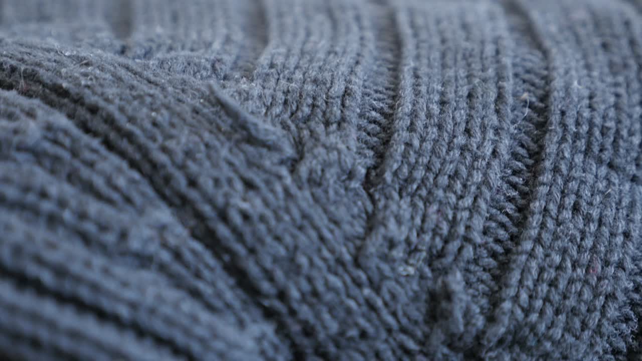 Slow tilt over ribbing or stockinette stitch knitting work 4K 2160p 30fps UltraHD footage - Close-up of warm wool gray sweater details and knitwork 3840X2160 UHD tilting video