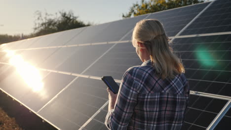 Frau-Mit-Smartphone-Geht-Wassermann-Sonnenkollektoren-Zu-Hause-Solarkraftwerk